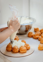 confectioner make eclairs with cream
