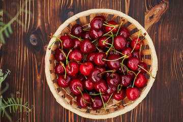 cherries in bowl and near on wooden background