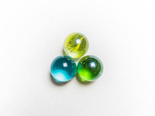 Three colored glass balls with caustics on a white background