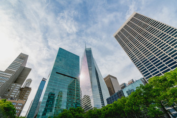 Fototapeta na wymiar New York City Skyscrapers, Bright Sun, and Beautiful Cloudy Blue Sky