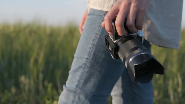 Female photographer in nature with a camera. Female hands with a camera.