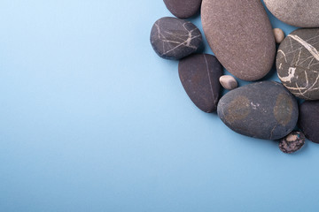 Fototapeta na wymiar Copy space pebbles summer background top view on blue background