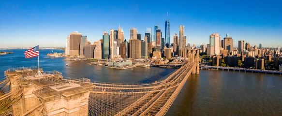 Fototapete Rund Brooklyn Bridge Amerikanische Flagge auf der Brooklyn Bridge mit Blick auf Manhattan im Hintergrund.  © Aerial Film Studio