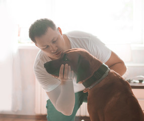 young man and his pet dog in a modern city apartment.