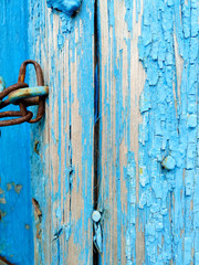 texture of old painted shabby rustic wooden fence made of planks, with rusty nails, hand-forged iron elements, grunge background