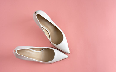 Light white high heels isolated on a bright pink pastel background. Fashion concept