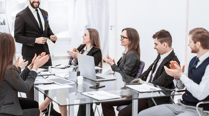 business team applauding to the Manager Finance on the presentation of the new project in the workplace