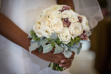 Obraz na płótnie Canvas wedding bouquet of white roses brides hands