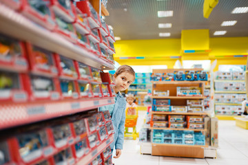 Little boy at the shelf in kids store
