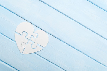 White heart made of symbolic autism puzzle pieces