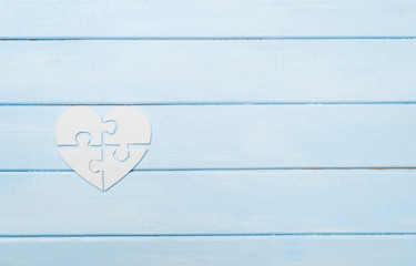 White heart made of symbolic autism puzzle pieces