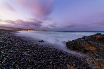 Beach with black volcanic sand in Spain Lanzarote Arriata while sunset