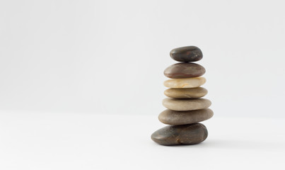 Balance, peace of mind, stones form a pyramid on a white surface, minimalism