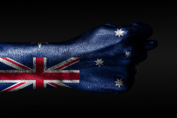 A hand with a painted Australia flag shows a fig, a sign of aggression, disagreement, a dispute on...