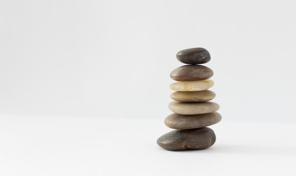 Balance, peace of mind, stones form a pyramid on a white surface, minimalism