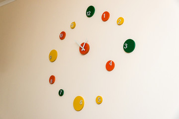creative clock in the form of multi-colored circles on the wall