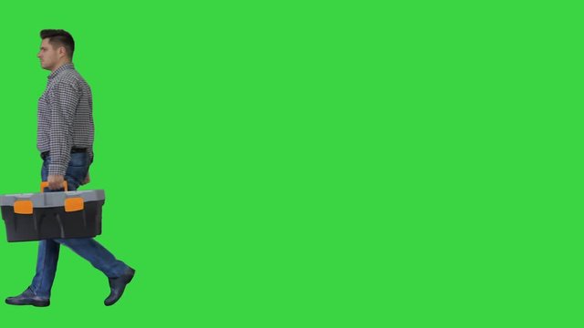 Professional repairman concept Handyman walking with tool case on a Green Screen, Chroma Key.