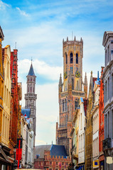 Fototapeta na wymiar The Belfry Tower (aka Belfort) and traditional narrow streets in Bruges (Brugge), Belgium