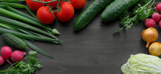 Fresh summer vegetables on a black wooden table