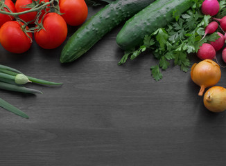 Fresh summer vegetables on a black wooden table