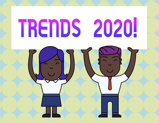 Conceptual hand writing showing Trends 2020. Concept meaning general direction in which something is developing or changing Two Smiling People Holding Poster Board Overhead with Hands