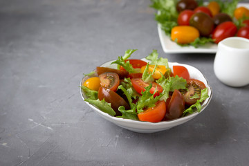 Fresh tomatoes and lettuce on a white plate.