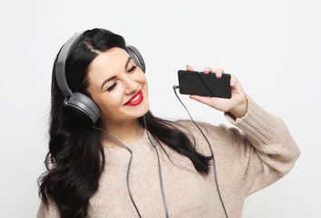 young curvy brunette woman in headphones listening to music  