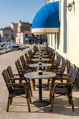 Empty tables and chairs of a cafe in Cres