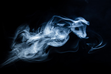 White, blue cigarette smoke on a black background. Stop smoking