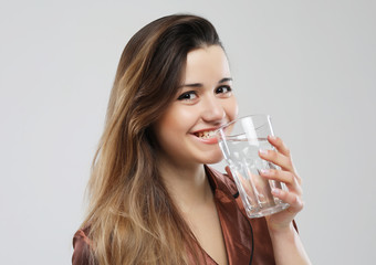 lifestyle and people concept - young woman wearing pajamas holding water glass