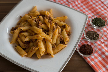 The pasta with spices on the wooden background for food photography concept.