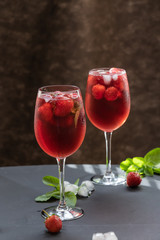Refreshing drink with strawberries and mint on a table. Perfect for party or hot days.