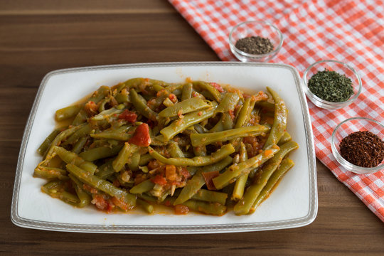 olive oil green beans in the white plate on the wooden table for restaurant or kitchen concept.