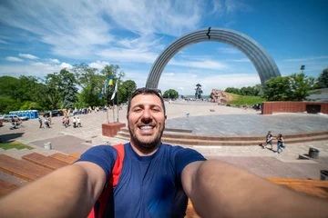 Fototapeten Happy tourist traveling in Ukraine taking selfie in front of the Monument to Reunion of Ukraine and Russia in Kiev, Ukraine © photomaticstudio