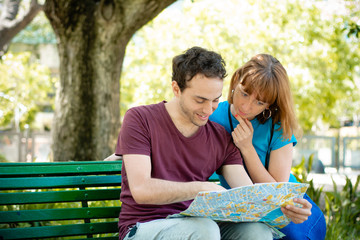 Couple holding map in hands and traveling together.