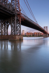 Williamsburg Bridge and Financial District from east river at sunrise with long exposure