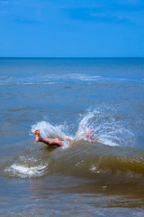 Unidentified romping romping through ocean wave.