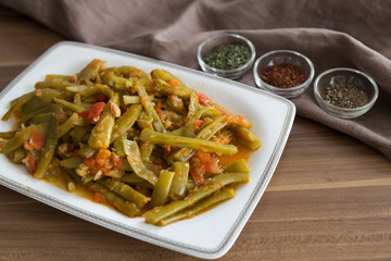 olive oil green beans in the white plate on the wooden table for restaurant or kitchen concept.