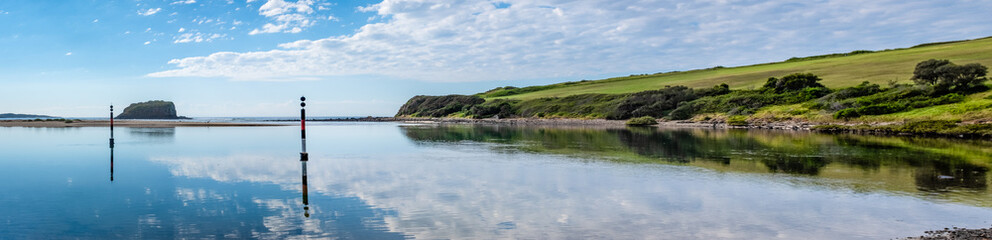 Still waters reflect the clouds a panoramic view across mouth of tidal river, Minnamurra river,...
