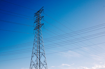 electricity pylon against blue sky