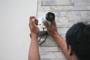Technician installing CCTV camera for security service.
