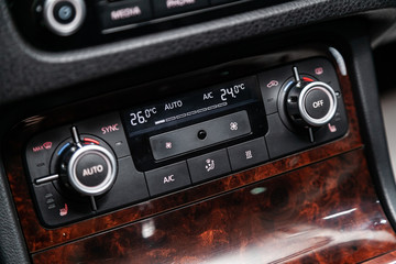 Сlose-up of the car  black interior:  seat heatting buttons, adjustment of the blower, air conditioner and other buttons.