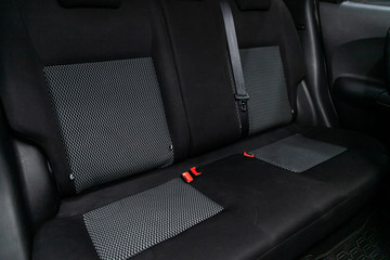 Сlose-up of the car   interior: black rear seats and seat belts .