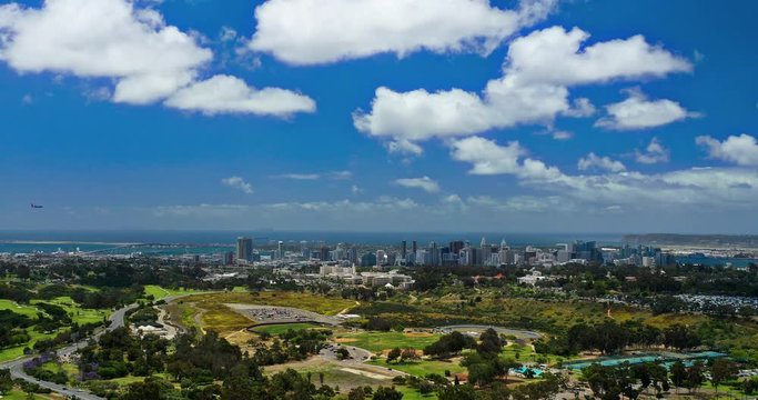 Aerial timelapse of Balboa Park with San Diego, the bay and Coronado bridge in the distance.