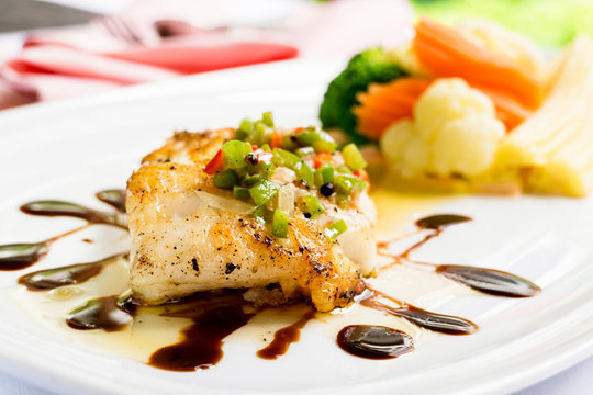grilled snapper fish steak with vagetable : Healthy lunch grilled snapper fish fillet with fresh salad close-up on a white plate.