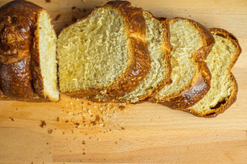 Slice Brioche toast loaf with bread crumbs on wood cutting board, bakery or breakfast concept.