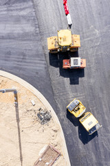 large road rollers and heavy compactor at road construction site. aerial view