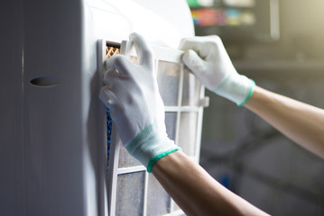 Check and repair electrical appliances in the home, Repairman is cleaning air conditioner. Close-up.