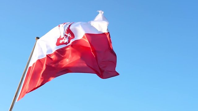 Slow motion. Flag of Poland. Big flag with empble on blue sky