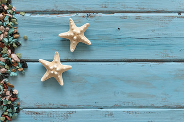 Summertime concept with starfish ond marine rubble on a blue wooden background. Top view.